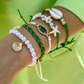 Primer plano de un set de pulseras bohemias con conchas y estrellas de mar en la muñeca - Juego de 5 Piezas Verde (26165-green)