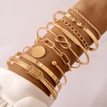 Close-up of 10-piece gold bracelet set featuring infinity charms and polished metal cuffs - Infinity Symbol and Cuban Chain 10-Piece Set (27572-gold) / Gold