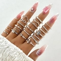 Dettaglio ravvicinato di un set di anelli vintage in argento con farfalla e perle - Stile argento 26550