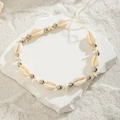 Close-up of beach body chain with natural cowrie shells and silver starfish on white stone - White - Style 1 (23898-1-white)