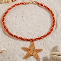 Goldener Seestern-Anhänger an roter Kordel auf weißem Sand am Strand - Seestern(26700-color red) / Rot