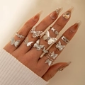 Silver butterfly ring set worn by a model with rhinestone nails on beige background - Butterfly 10-Piece Set (26568-silver) / Silver