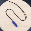 Lapis Lazuli hexagonal crystal pendant with a black woven cord on a wooden tray - Lapis Lazuli With Cord