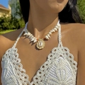 Detail of bohemian shell necklace with a golden starfish pendant worn by a model - White Conical Shell Gold Base (27259-white)