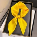 Detail of bright yellow satin scarf with soft pearl luster on a minimalist black tray - Goose Yellow