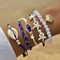 Dettaglio di un set di bracciali bohémien con conchiglie e perle indossati sulla spiaggia - Blu (26165-blue)