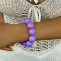Ethnic style chunky purple beaded bracelet shown on a wrist for a casual bohemian look - Purple