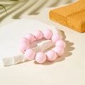 Close-up of pink oversized beaded bracelet on a white stone pedestal with soft shadows - Pink