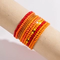 Detail of multi-layered elastic beaded bracelets in vibrant red, orange and yellow tones - Red/Orange/Yellow/Gold Layered Warm Colors (28228-orange)