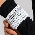 Close-up of stacked bohemian multi-layer white beaded bracelets on model's wrist - Pure White/Translucent Layered Style (28437-white)