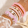 Detail of layered bohemian beaded bracelets with starfish charms on a sunny beach - Pink Ocean Style Star/Starfish (28298-pink)