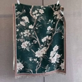 Detail der Jacquard-Textur des dunkelgrünen Pashmina-Schals mit Blumenmuster und Fransen - Grün