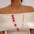 Dettaglio della collana lunga con perle rosa e bianche su un maglione beige - Stile Fiore Perle Rosa Bianco (27415-gold)