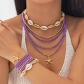Boho sieradenset met paarse kralen en zeesterbedeltjes gedragen door een model - Paars
