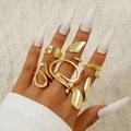 Close-up of golden irregular wavy rings set worn on fingers with smooth polished finish - Gold Fluid Lines Open Set (28255-gold)