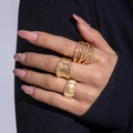 Close-up of gold layered stackable rings and textured bands worn on a model's hand - Gold Wide Hammered Texture Set (28784-golden)