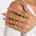 Gros plan de huit bagues dorées minimalistes avec des motifs ondulés et des textures - Ensemble 8 Pièces Serpent Vague Or (27231-gold)