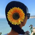 Outdoor shot of a woman wearing a large yellow sunflower hair clip by the sunny seaside - Sunflower (27679)
