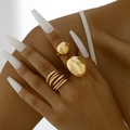 Detailweergave van een driedelige gouden geometrische ringenset aan de hand - 3-delige set / Goud