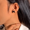 Gros plan détaillé de boucles d'oreilles nœuds noir mat portées sur le lobe - Boucles d'Oreilles Clous Noeud Minimaliste Noir Mat (28760-black)