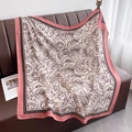 Sciarpa quadrata con rose e bordi rosa adagiata su un divano in pelle marrone - 90*90cm / Bordo Rosa (HSM-64-Bordo Rosa)