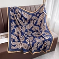 Detalle de un pañuelo de seda con estampado paisley azul marino sobre un sofá de cuero - 90*90cm / Estilo de Cachemira Azul Marino (HSM-65-Azul Marino)