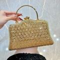 Elegante goldene Abendtasche mit geometrischen Cut-outs und Kristallen von Model gehalten - Gold