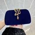 Dark blue velvet evening clutch featuring a gold snake-shaped rhinestone buckle - Blue