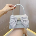 Detail view of a silver sequin evening bag with large satin bow and crystal buckle - Silver