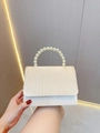 Detailed view of cream pleated evening bag with elegant large pearl handle for weddings - Apricot