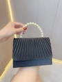 Detailed view of black pleated satin evening bag with decorative faux pearl top handle - Black