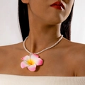 Gros plan d'un pendentif fleur de frangipanier sur un collier de perles porté par un modèle - Collier Perles Plumeria (27524-1-pink)