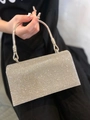 Detailed close-up of a silver evening clutch bag featuring dense sparkling rhinestones - Silver