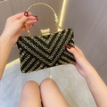 Macro view of vintage gold handle with floral relief on rhinestone evening clutch - Black