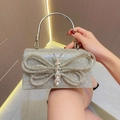 Detalle del bolso de noche plateado con pedrería, mariposa de cristal y asa metálica redonda - Plateado