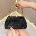 Detailed close-up of a black beaded evening clutch with gold metal handles and top pearl clasp - Black