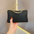 Detalle de bolso de fiesta con lentejuelas negras, lazo de strass y asa metálica - Negro