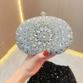 Detail of silver evening clutch bag featuring intricate floral rhinestone pattern and clasp - Silver