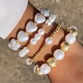 Détail d'un ensemble de bracelets cœur et perles portés au poignet sous lumière naturelle - Combinaison Perle Coeur Perle Dorée (27895-1-white)
