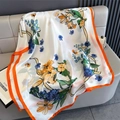 Close-up of floral print satin shawl with vibrant orange borders and silky texture - Orange Edge