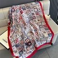 Detail of silk-like red shawl with colorful geometric abstract patterns on beige leather - Red Edge