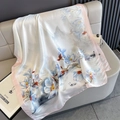 Dettaglio di sciarpa in seta con fiori di magnolia blu e bordo rosa su divano in pelle - Bordo Rosa