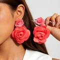 Détail de boucles d'oreilles roses 3D en tissu rouge portées pour un look mode - Style Rose 3D (27843) / Corail
