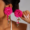 Nahaufnahme der rosa Stoff-Kamelien-Ohrringe mit Quasten aus Acrylperlen - Rosarot