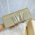 Elegant gold sequin clutch bag with pleated detail held by model in evening dress - Gold