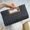 Schwarze gewebte Stroh-Clutch mit goldenem Griff und elegantem Fischgrätenmuster-Design - Schwarz
