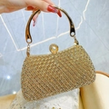 Clutch da sera color oro champagne con strass e chiusura a perla tenuta in mano - Oro