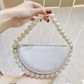 Detail of a semi-circular evening bag featuring large pearl handles and silver metallic finish - Silver with White Pearl Handle