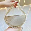 Detail of champagne gold crescent evening bag featuring a white pearl beaded handle strap - Gold with White Pearl Handle