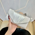 Dettaglio della pochette da sera in raso plissettato argento con patta a V in mano - Bianco